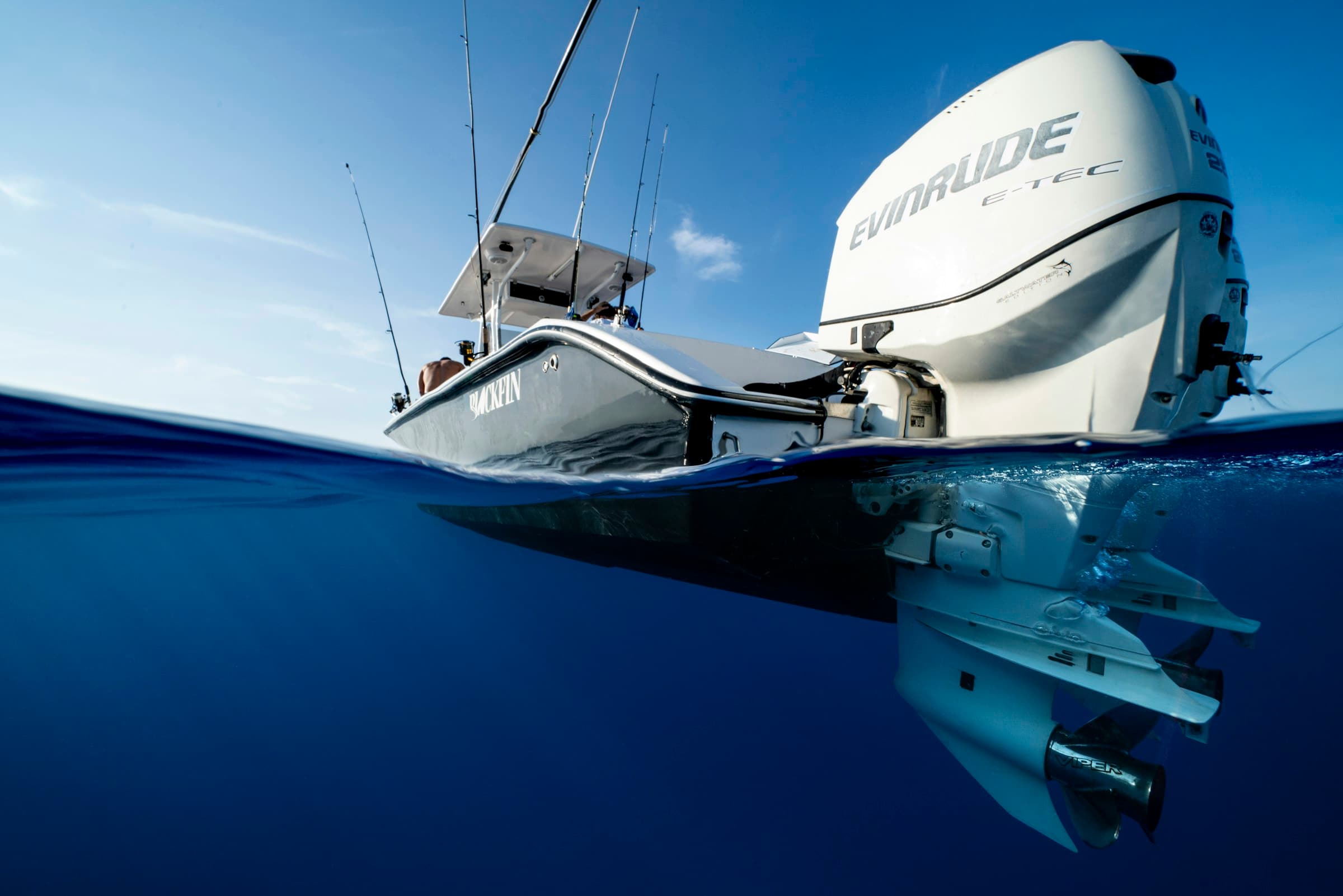 A center console fishing boat seen from the waterline, its outboard in the foreground